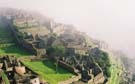 Machu Picchu in the mist - sun starts to burn the mist